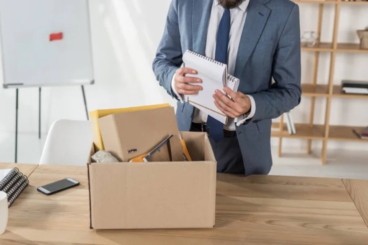 Una persona mentre lascia la sua postazione di lavoro (Depositphotos)