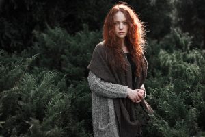 woman in gray knit sweater standing near green plants during daytime