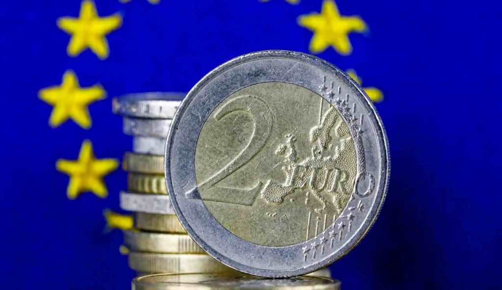 Moneta da 2 euro davanti alla bandiera europea