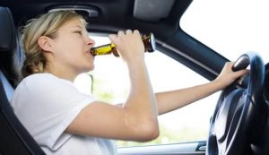 Una ragazza mentre beve in auto (Depositphotos)